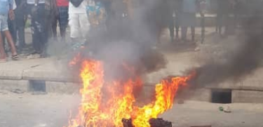 Graphic photos: Armed Robber Set Ablaze After Shooting Lady Dead Outside A Bank In Lagos