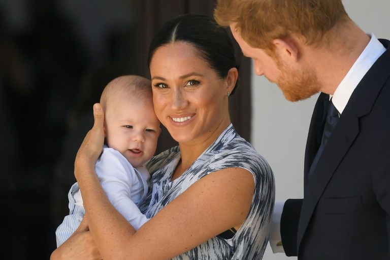 Prince Harry and Meghan Markle carrying their son