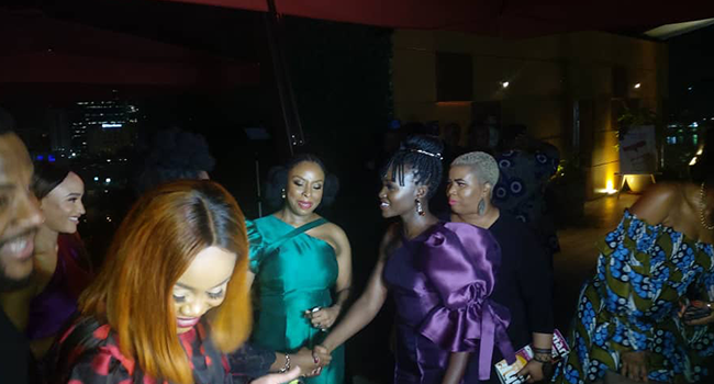 Lupita Nyong’o (L) and Chimamanda Adichie greet guests at an event in Lagos on Saturday, February 22, 2020.