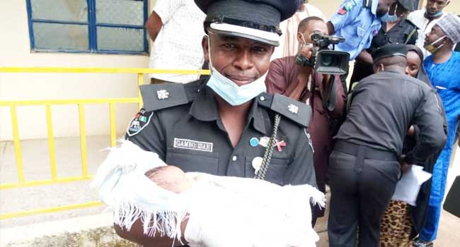 The spokesman of the Katsina State Police Command, Gambo Isah, holds a baby said to have been trafficked by two nurses during a conference on August 3, 2020.