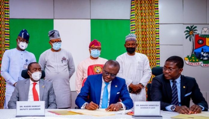 Lagos State Governor, Mr. Babajide Sanwo-Olu signing bills in to Law flanked by his Deputy, Dr. Obafemi Hamzat (left) and Head of Service, Mr. Hakeem Muri-Okunola (right) at the Lagos House, Alausa, Ikeja, on Monday, March 15, 2021. Behind are (L-R): Chairmen, Lagos State House of Assembly Committees: Hon. Rauf Age-Sulaiman (Procurement); Hon. Victor Akande (Judiciary); Hon. Nurudeen Solaja-Saka (Public Account) and Hon. Hakeem Sokunle (Health).