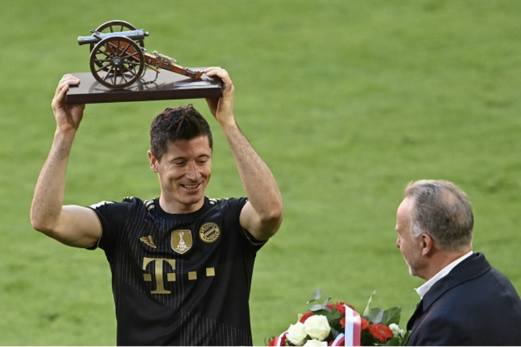 Bayern Munich’s Polish forward Robert Lewandowski celebrates with the trophy for the leading goal scorer of the Bundesliga season after the German first division Bundesliga football match Bayern Munich vs FC Augsburg in Munich, southern Germany, on May 22, 2021. (Photo by CHRISTOF STACHE / POOL / AFP)