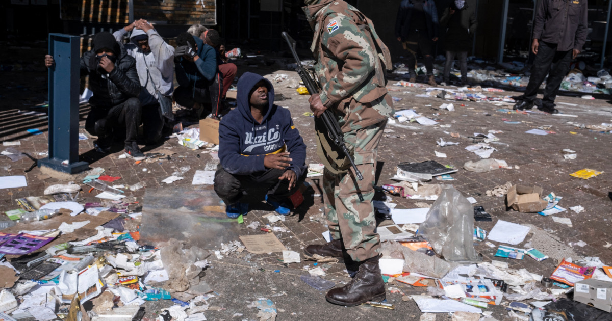A suspected looter pleads with a South African National Defence Force (SANDF) soldier who is arresting suspected looters at the Jabulani mall in Soweto on the outskirts of Johannesburg on July 13, 2021 [Emmanuel Croset/AFP]