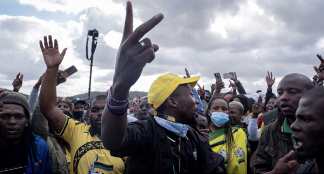 Supporters gesture as they gather in front of former South African president Jacob Zuma’s rural home in Nkandla on July 4, 2021. Emmanuel Croset / AFP